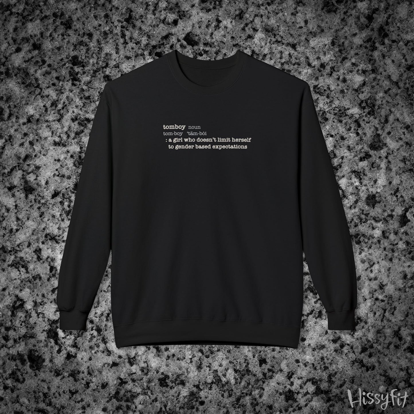 Black sweatshirt with text definition of "Tomboy" on a gray and black speckled background