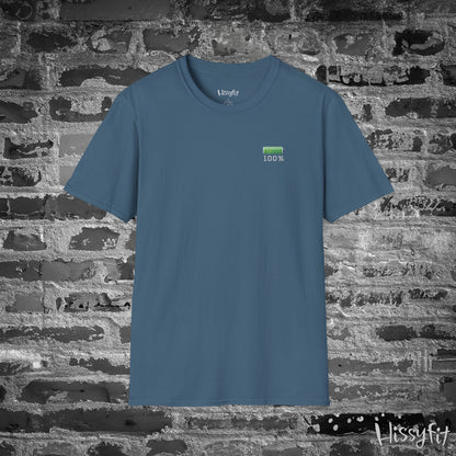 Blue t-shirt with a green battery symbol displaying '100 percent charged' on a brick wall background