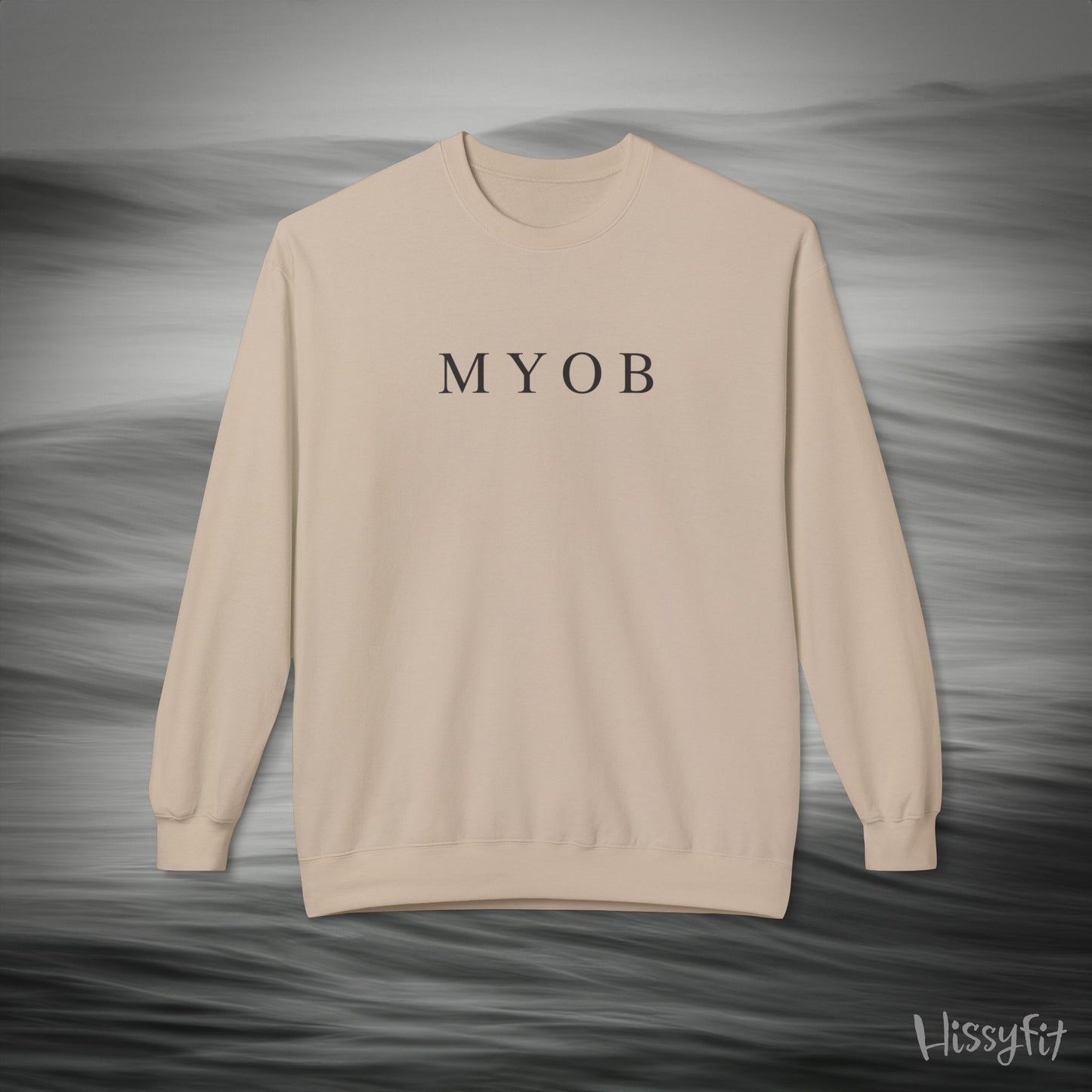 Beige sweatshirt with 'MYOB' text on a gray background