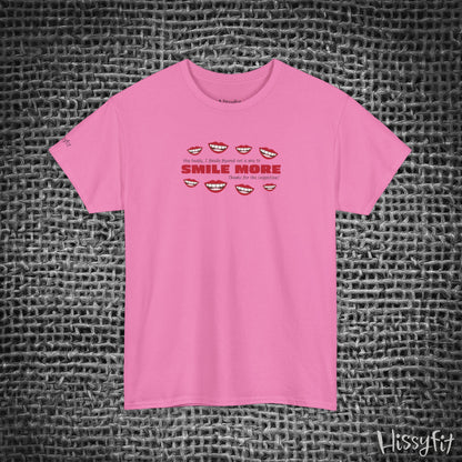 Pink t-shirt with text 'Smile more' and smiley faces on a textured gray background