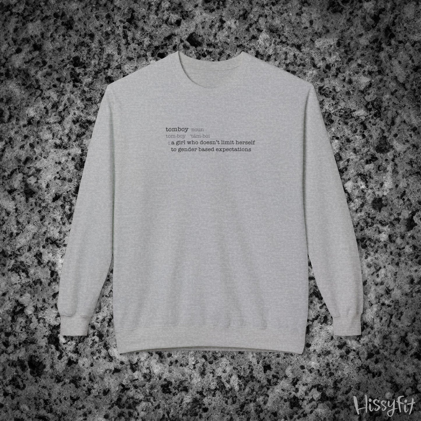 Gray sweatshirt with text definition of "Tomboy" on a gray and black speckled background
