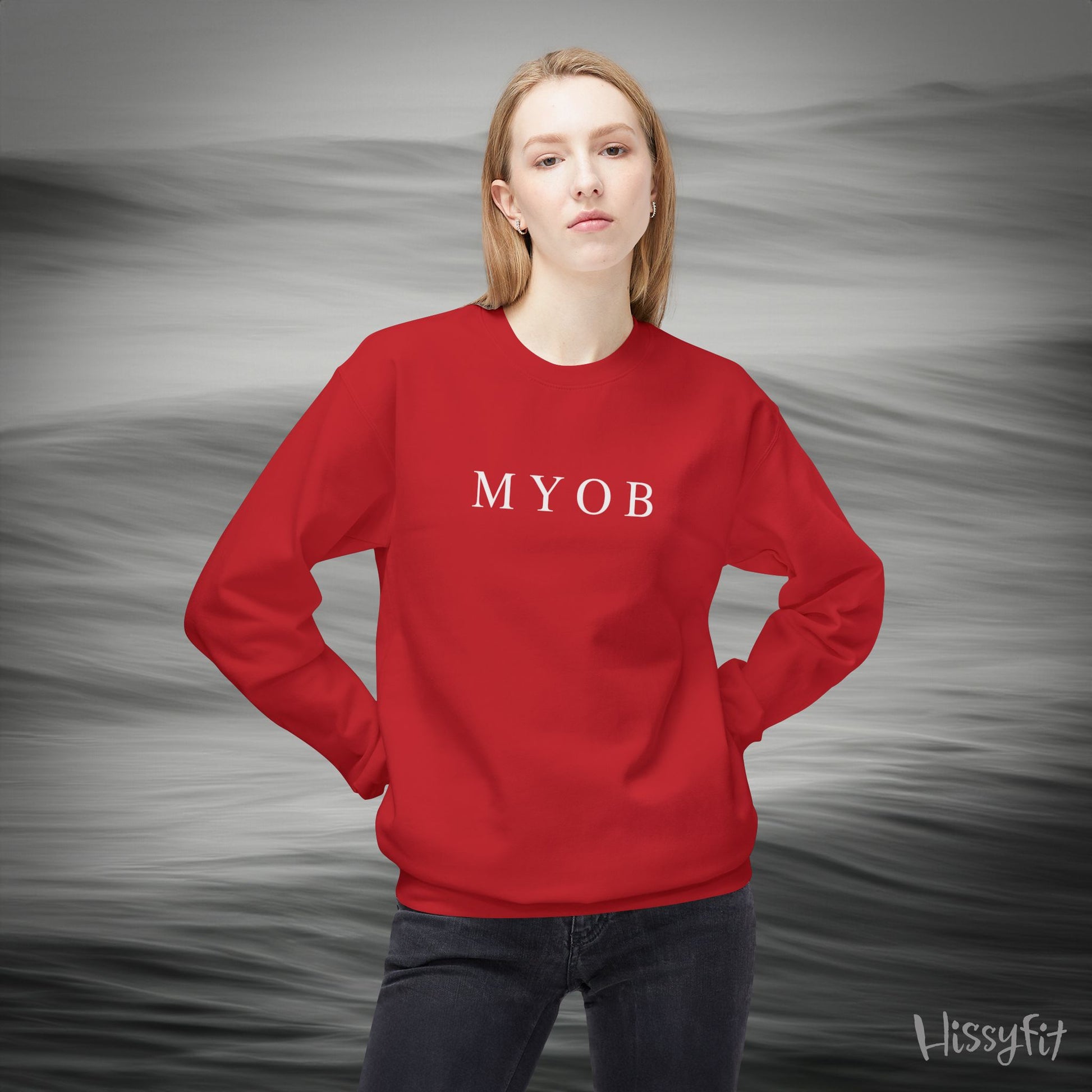 Person wearing a red sweatshirt with 'MYOB' text against a gray background