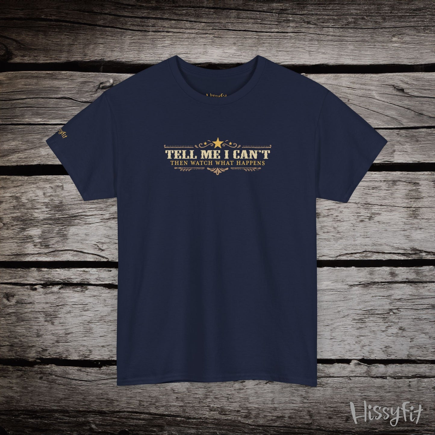 Navy blue t-shirt with text 'Tell me I can't then watch what happens' on a wooden surface, featuring the brand 'Hissyfit'.