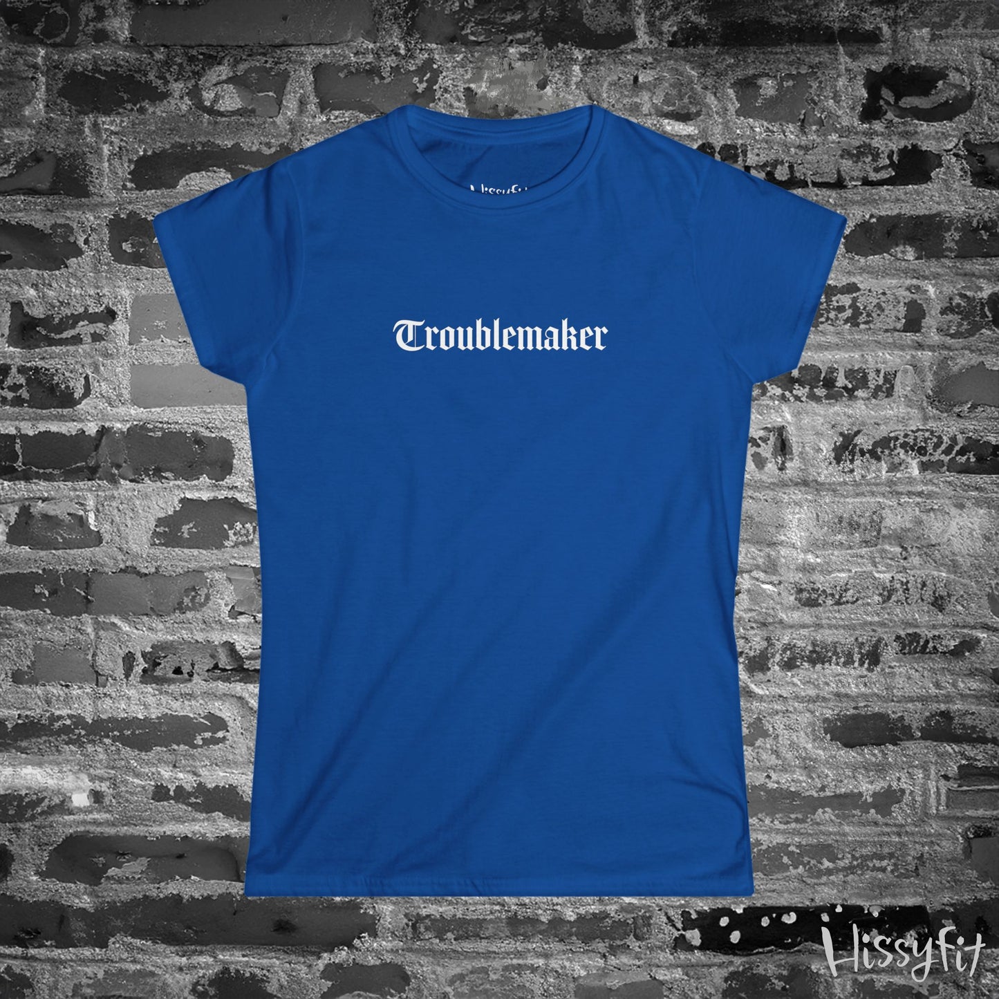 Blue t-shirt with 'Troublemaker' text on a brick wall background