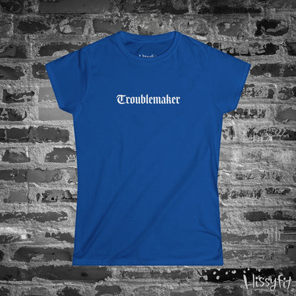 Blue t-shirt with 'Troublemaker' text on a brick wall background