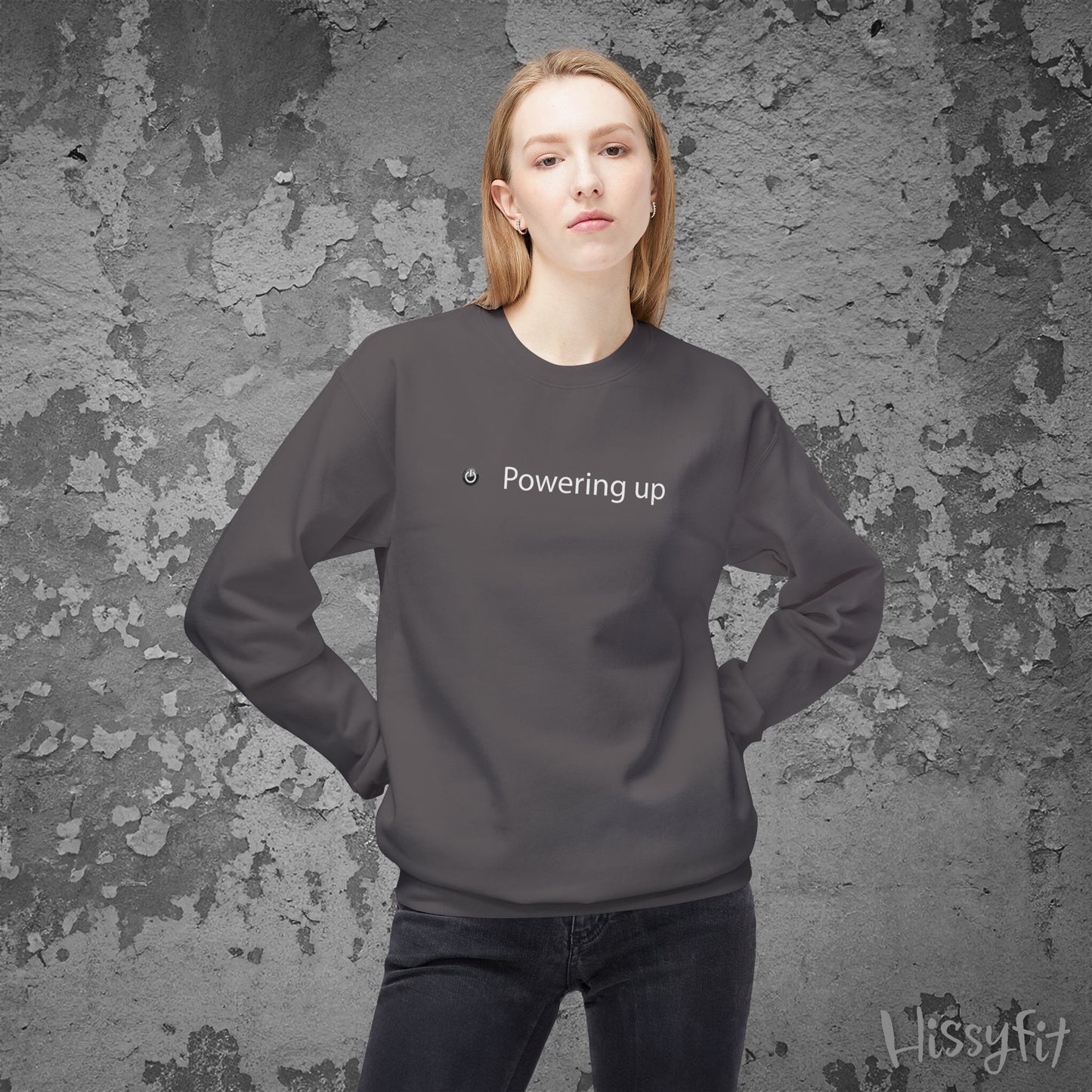 Person wearing a dark gray sweatshirt with 'Powering up' text against a textured gray background