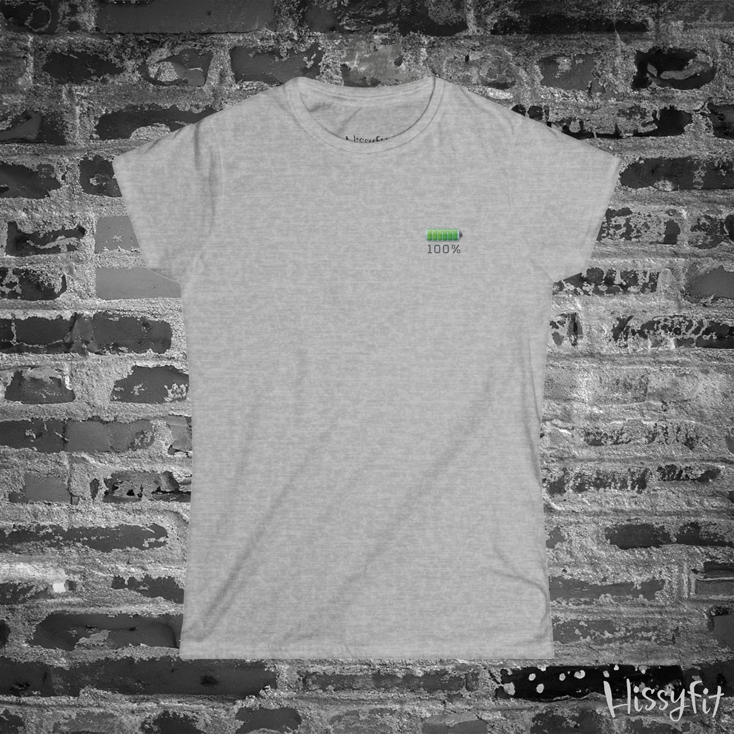 Gray t-shirt with a green battery symbol and '100%' charged on a brick wall background
