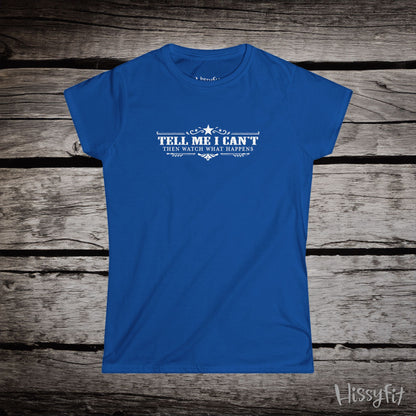 Blue t-shirt with text 'Tell me I can't then watch what happens' on a wooden surface, featuring the brand 'Hissyfit'.