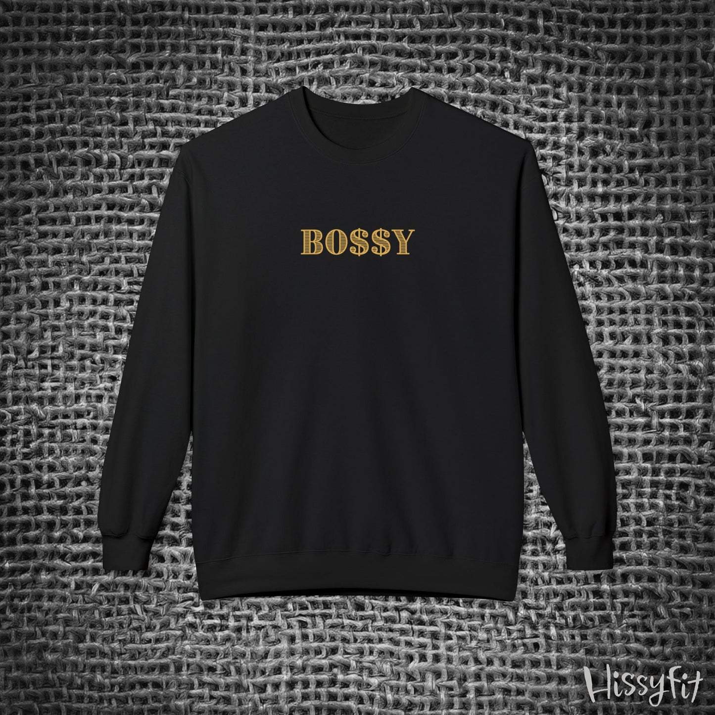 Black sweatshirt with 'BOSSY' in gold on a textured gray background