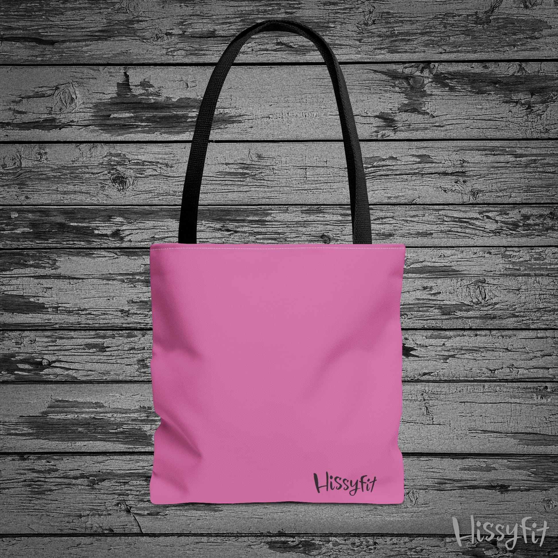 Pink tote bag with 'Hissyfit' branding on a wooden surface