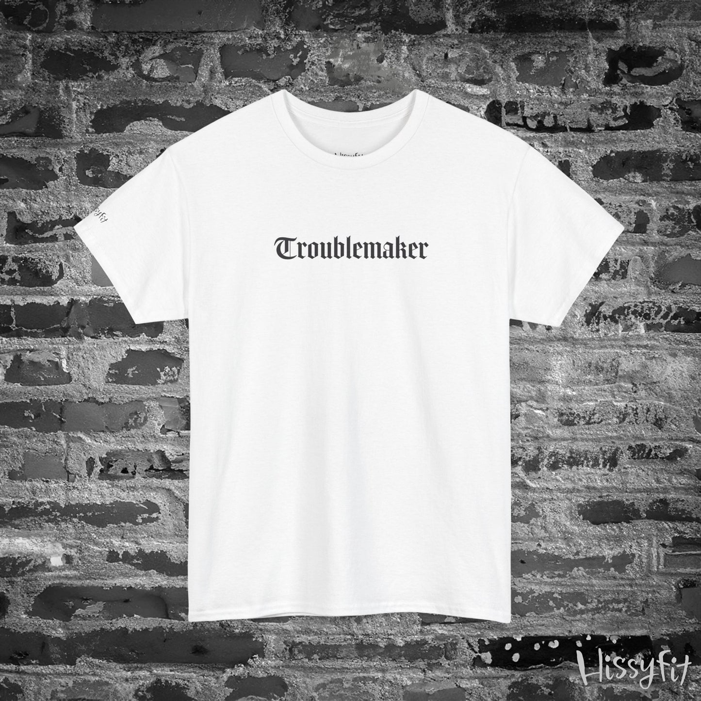 White t-shirt with 'Troublemaker' text on a brick wall background