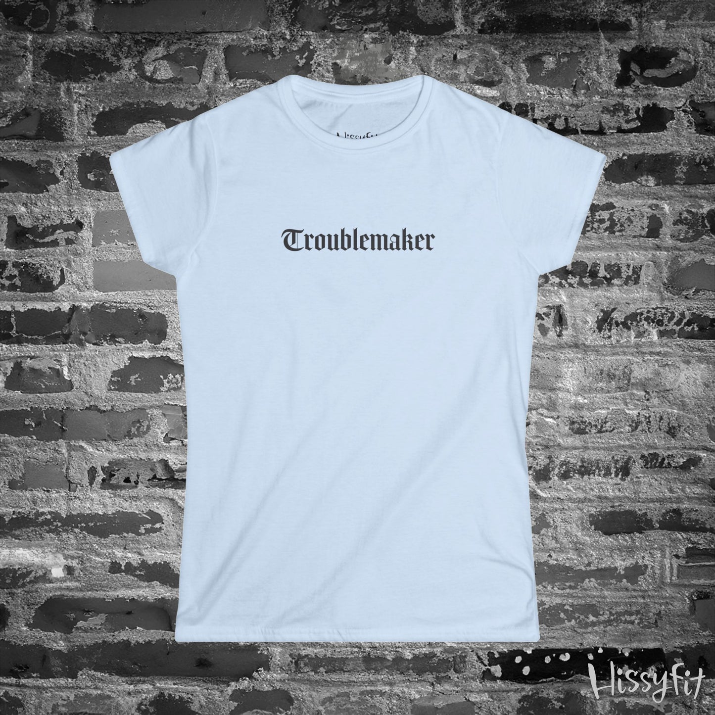 Light Blue t-shirt with 'Troublemaker' text on a brick wall background