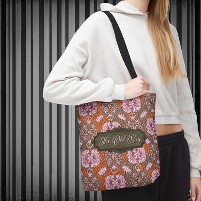 Person holding a floral-patterned bag with 'The Old Bag' label against a striped background