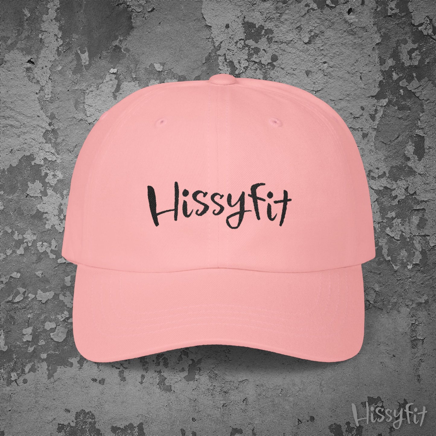 Pink cap with 'Hissyfit' text on a textured gray background