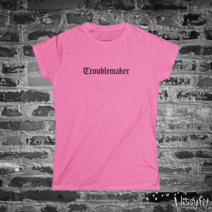 Pink t-shirt with 'Troublemaker' text on a brick wall background