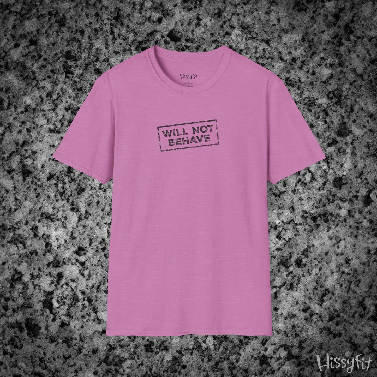 Pink t-shirt with 'WILL NOT BEHAVE' text on a gray granite surface, brand 'Hissyfit' visible.
