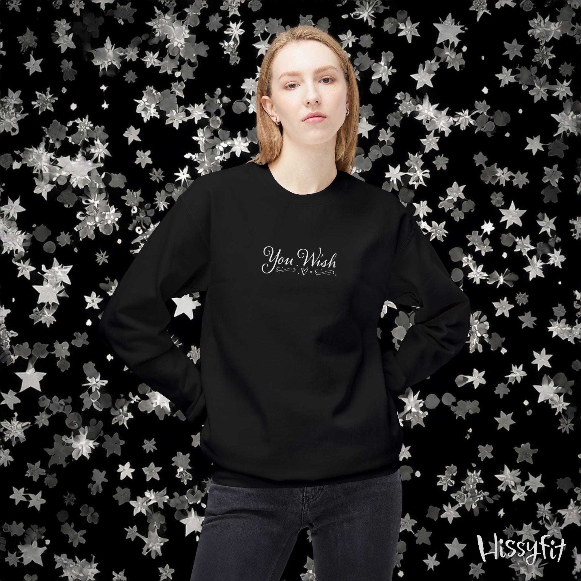 Person wearing a black sweatshirt with 'You Wish' text against a star-patterned background