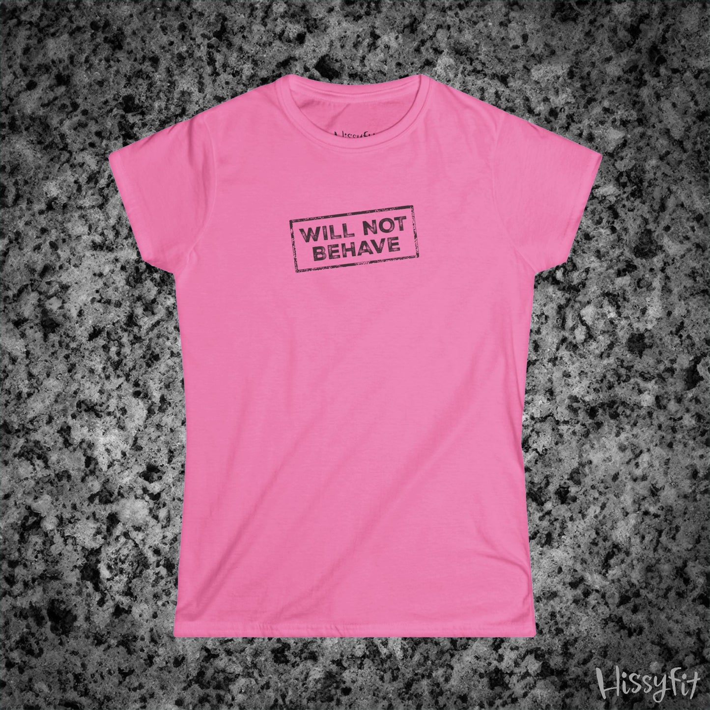 Pink t-shirt with 'WILL NOT BEHAVE' text on a gray surface, brand 'Hissyfit' visible.