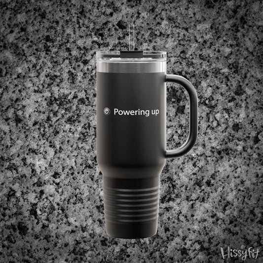 Black travel mug with 'Powering up' text on a gray granite background