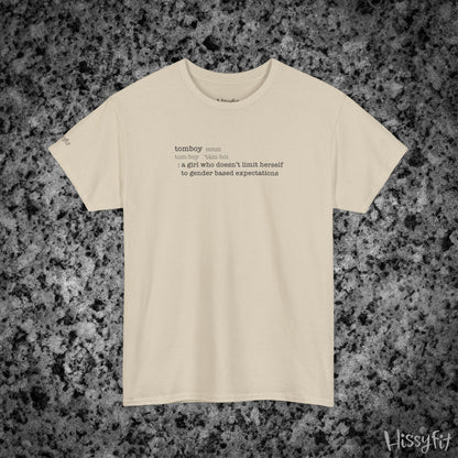 Beige t-shirt with text 'Tomboy:definition' on a gray and black speckled background