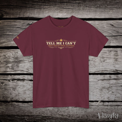 Maroon t-shirt with text 'Tell me I can't then watch what happens' on a wooden surface, featuring the brand 'Hissyfit'.