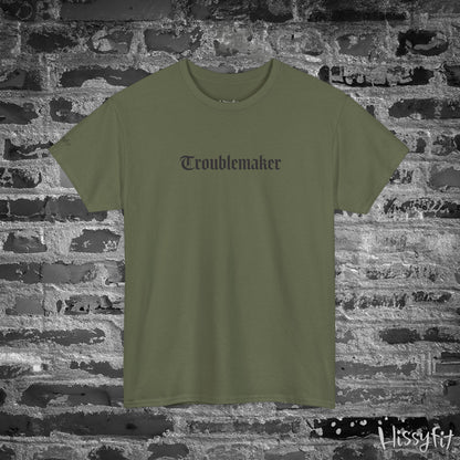 Green t-shirt with 'Troublemaker' text on a brick wall background