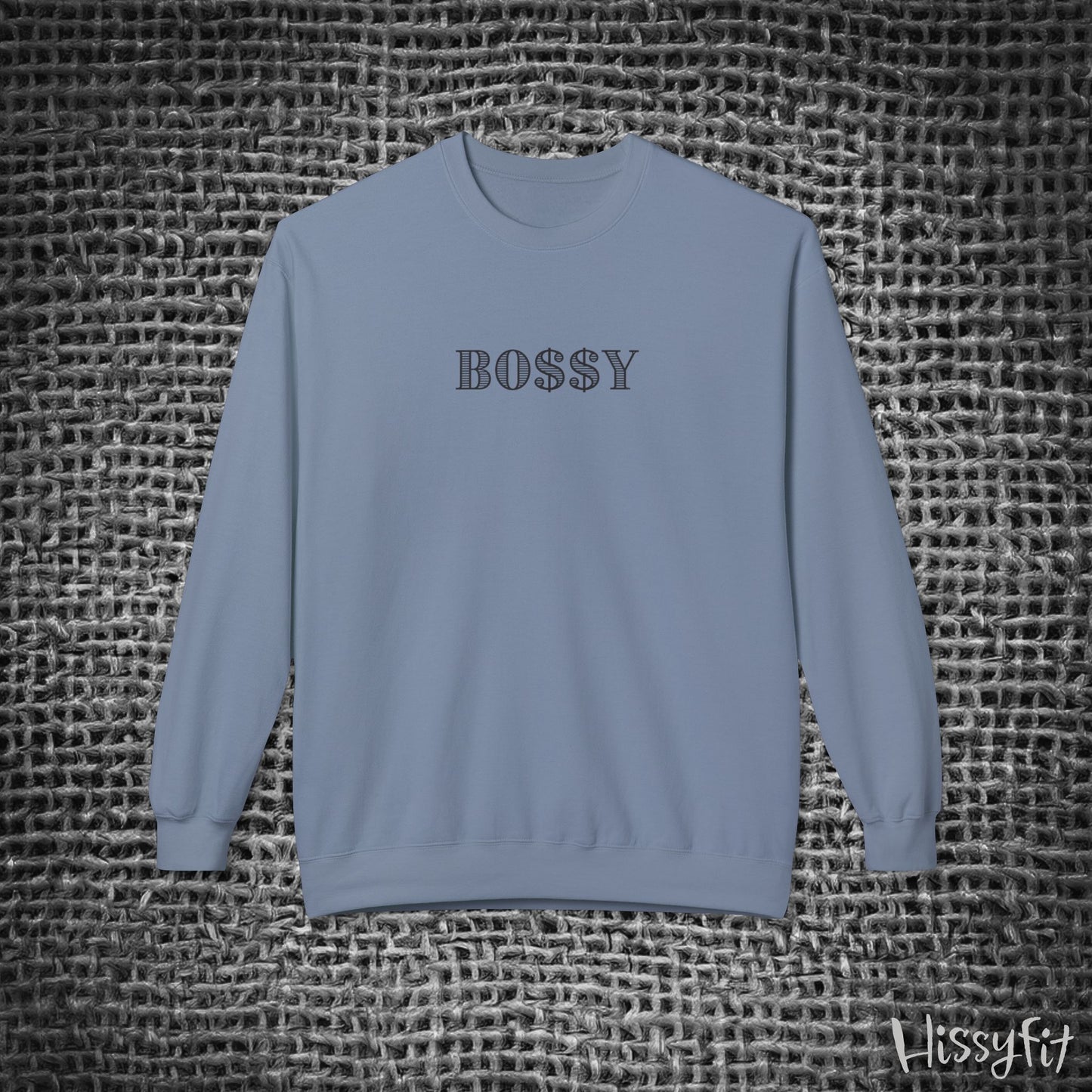 Blue sweatshirt with 'BOSSY' text on a textured gray background