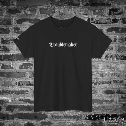 Black t-shirt with 'Troublemaker' text on a brick wall background