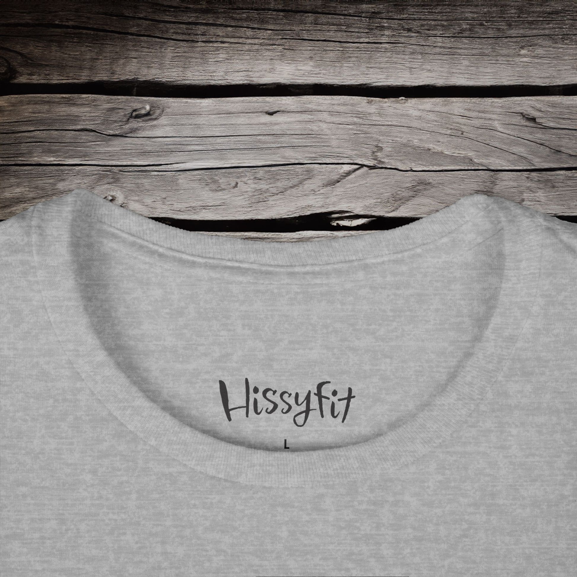 Gray sweatshirt with 'Hissyfit' text on a wooden surface