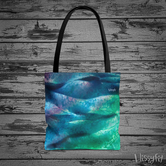 Tote bag with abstract blue and green design on a wooden surface
