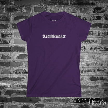 Purple t-shirt with 'Troublemaker' text on a brick wall background